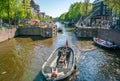 Amsterdam, May 7 2018 - small boat with locals passing the lock