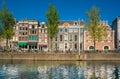 Amsterdam, May 7 2018 - tourist and locals walking by the Singel channel with old traditional buildings in the background