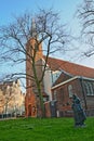 The internal courtyard of Begijnhof, one of the oldest hofjes in Amsterdam, with the statue of a beguine in the foreground