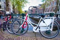 AMSTERDAM, THE NETHERLANDS - APRIL 25, 2015: The life of canals and streets. Bikes parked along the bridge Royalty Free Stock Photo