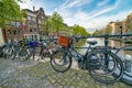 AMSTERDAM, THE NETHERLANDS - APRIL 25, 2015: The life of canals and streets. Bikes parked along the bridge Royalty Free Stock Photo