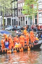 Amsterdam, Netherlands - April 27, 2019: Party boat with people dressed in national orange color while celebrating the