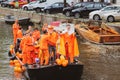 Amsterdam, Netherlands - April 27, 2019: Party boats on canal with people dressed in national orange color while celebrating the