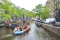 Amsterdam, Netherlands - April 27, 2019: Party boats with people dressed in national orange color while celebrating the