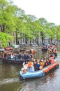 Amsterdam, Netherlands - April 27, 2019: Party boats with people dressed in national orange color while celebrating the
