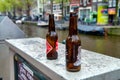 AMSTERDAM, THE NETHERLANDS - APRIL 25, 2015: Two beer bottles abandoned along the city canal. Many people gets drunk in the night