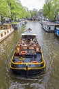 Amsterdam, the Netherlands - 13 August 2017: canal cruise boat passing houseboats in Amsterdam Royalty Free Stock Photo