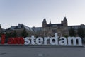 I am amsterdam giant lettering touristic sign in front of Rijkmuseum at sunny blue dusk