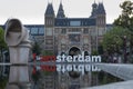 Rijkmuseum facade with touristic amsterdam lettering sign on sunny sunset