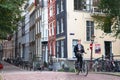 Street scene from Amsterdam with person riding a bicycle and typical architecture