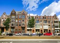 AMSTERDAM, NETHERLANDS - AUGUST 3, 2017: Traditional dutch house, cars and people on street. summer touristic season.