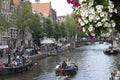 wo boats full of tourist sailing into Amstel canal in summer scene