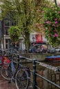 Amsterdam, Netherlands, 12/10/2019: Bicycles on a canal in a European city. Old architecture, flowering trees. Vertical Royalty Free Stock Photo