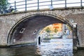 Amsterdam, Netherlands, 08/22/2015: Canal with a brick arch in the city