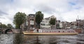 Canal tour boat giving tourist rides. Urban landscape and historic building