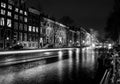 AMSTERDAM, NETHERLANDS - DECEMBER 14, 2015: Black-white photo of cruise boat moving on night canals of Amsterdam Royalty Free Stock Photo