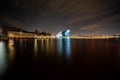 NEMO science museum at center of Amsterdam. Futurist building at Oosterdok at night with passing canal boats