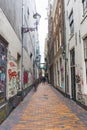 04.18.2023 Amsterdam, Netherlands. Empty Amsterdam street in between building blocks. Graffiti on the walls. Vertical