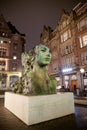 The modern bronze sculpture in the form of a woman`s head in night time