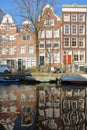 AMSTERDAM, NETHERLANDS - FEBRUARY 23, 2019: Reflection of crooked and colorful heritage buildings along Egelantiersgracht Canal