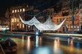 Crochet and illuminated giant bedspread float above a canal during the Festival of Light in Amsterdam