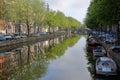 Crooked and colorful heritage buildings and boats, overlooking Herengracht canal with perfect reflections