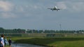 People are watching airplane approaching to airport