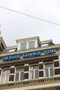 It teaches `Jesus loves you` on the facade of a building