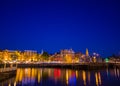 Amsterdam, Netherlands - July 10, 2015: Water channels by night, beautiful dark blue sky and city lights on both sides