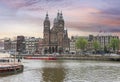 Amsterdam, Netherlands - June 2019: Basilica of Saint Nicholas Sint Nicolaaskerk over Damrak canal