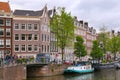 AMSTERDAM, NETHERLANDS - JUNE 25, 2017: Old buildings near the one of the water canals. Royalty Free Stock Photo