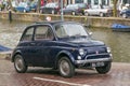 AMSTERDAM, NETHERLANDS - JUNE 25, 2017: Old retro Fiat car under the rain near the one of the water canals. Royalty Free Stock Photo