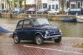 AMSTERDAM, NETHERLANDS - JUNE 25, 2017: Old retro Fiat car under the rain near the one of the water canals. Royalty Free Stock Photo