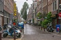 AMSTERDAM, NETHERLANDS - JUNE 25, 2017: View of the one of the town street under the rain in the historical part. Royalty Free Stock Photo