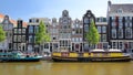 Crooked heritage buildings and colorful barges, located along Singel Canal