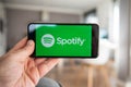 Man holding his phone, Spotify start screen on smartphone, mobile screen. Music content streaming subscription service.