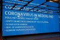 Coronavirus warning alert on electronic billboard in a Dutch train station