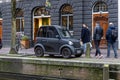 Modern small electric car Amsterdam in front of Hash Marihuana Museum