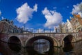 AMSTERDAM, NETHERLANDS, MARCH, 10 2018: Outdoor view of Amsterdam canals with people walking over a bridge and typical