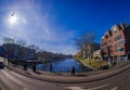 AMSTERDAM, NETHERLANDS, MARCH, 10 2018: Outdoor view of people walking close to the canals of Amsterdam, is the capital