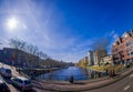 AMSTERDAM, NETHERLANDS, MARCH, 10 2018: Outdoor view of people walking close to the canals of Amsterdam, is the capital