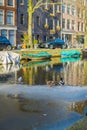 AMSTERDAM, NETHERLANDS, MARCH, 10 2018: Outdoor view of some cars parked close to a boats in the canals of Amsterdam