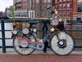 AMSTERDAM, THE NETHERLANDS - MAY 2021: Bicycle decorated with many clocks and timepieces on a bridge in the city center