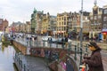 People walking on Damrak avenue at evening light in Amsterdam, Netherlands