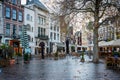Beautiful empty autumn city square with outdoor dining and incidental people in Amsterdam Netherlands.