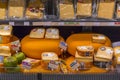 Different types of Dutch cheese wrapped and stacked in a grocery shop in Amsterdam Royalty Free Stock Photo