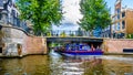 Canal boat under a bridge entering the Leidsegracht Leids Canal from the Prinsengracht Prince Canal in the center of Amsterdam