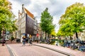 Locals biking over a canal bridge in the Jordaan neighborhood of Amsterdam Royalty Free Stock Photo