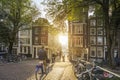 Amsterdam, Netherlands - September 22, 2021: People ride a bike. Early morning in Amsterdam. Sunny quiet street of an ancient Royalty Free Stock Photo