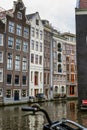 Amsterdam, Netherlands, 10/10/2019: Traditional old houses on the water in the center of a European city. Front view. vertical Royalty Free Stock Photo